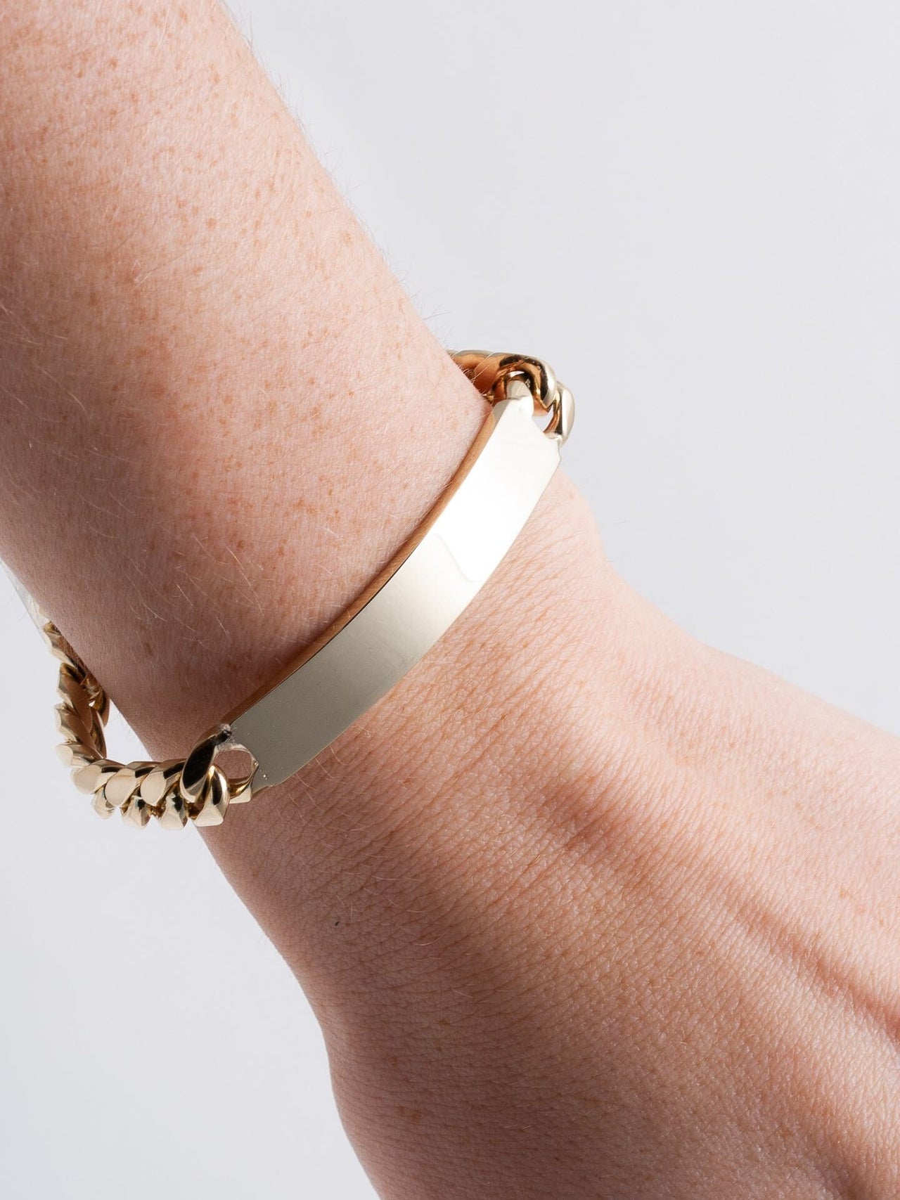 14kt Yellow Gold Solid XL Cuban Chain ID Bracelet pictured on models wrist. 