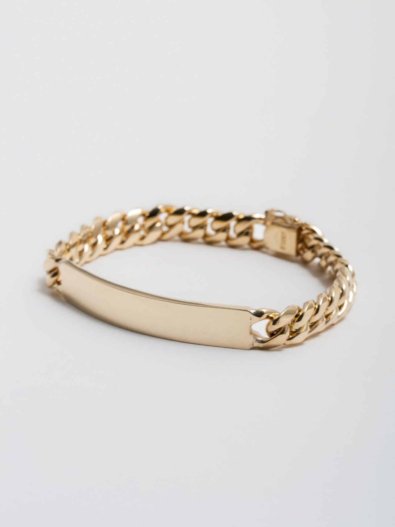 14kt Yellow Gold Solid XL Cuban Chain ID Bracelet clasped and pictured on light grey background. 