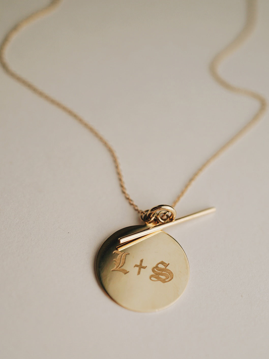 Close up of 14Kt Yellow Gold Disk and Toggle Necklace with Engraving: "L + S"