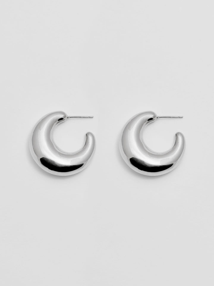 Sterling Silver Crescent Moon Earrings pictured on light grey background. 