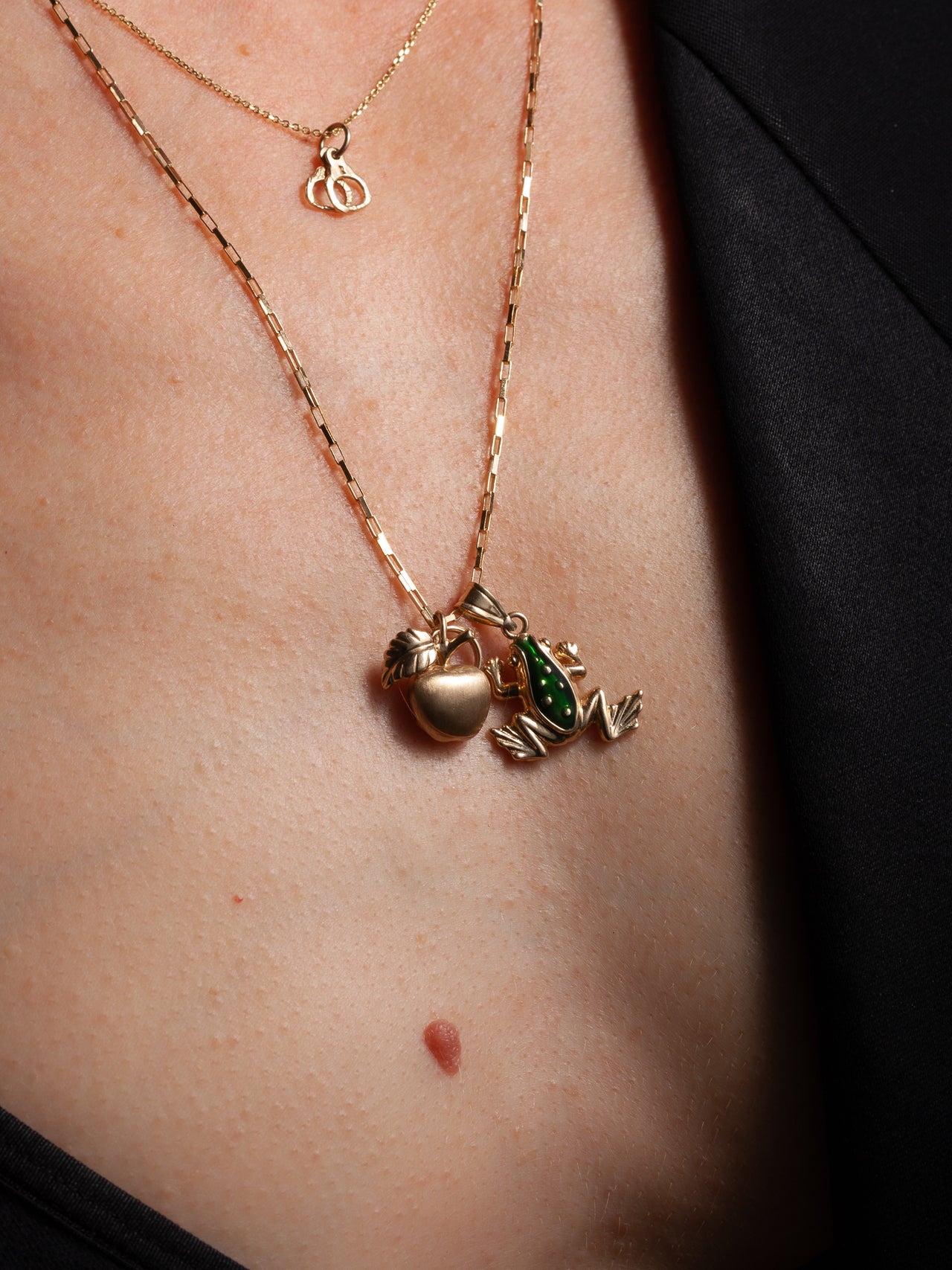 14Kt Yellow Gold Handcuff Charm pictured on model. Layered with another necklace with two charms. 