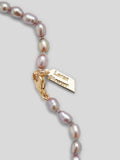 Close up of Loren Stewart logo and lobster clasp on lavender pearl necklace. 