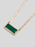 Close uop of gemstone Product image of 10kt yellow gold thin chain necklace with thin green rectangular gemstone on white background. 