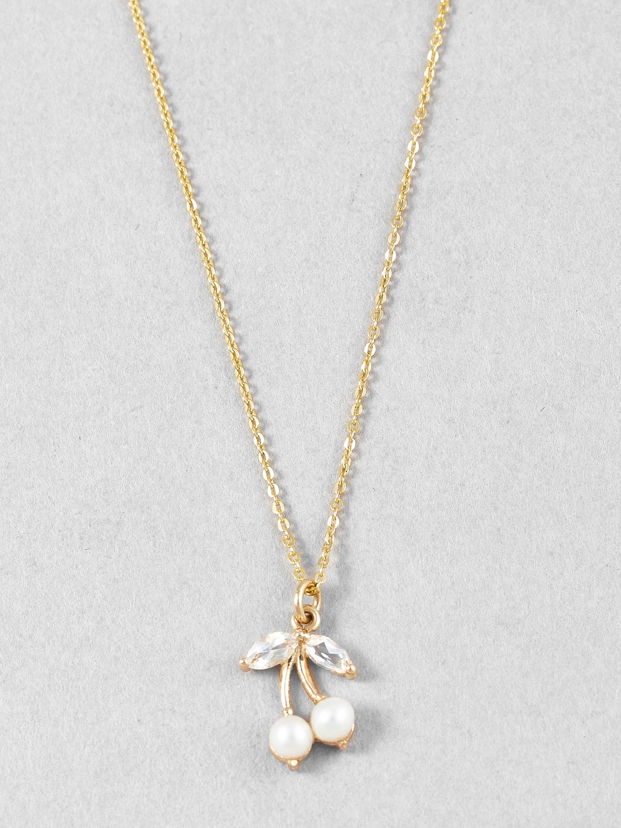 14Kt Yellow Gold Necklace with White Topaz & Pearl Cherry Pendant on gold chain shot on light grey background.