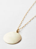 14kt Yellow Gold XL Disk Pendant, 30mm Width, shot on chain laying down. Light grey background.