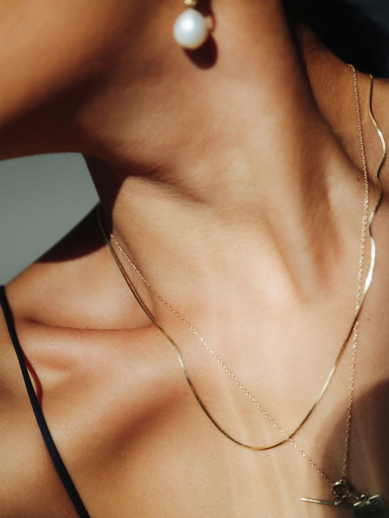 Demi Herringbone Necklace: 10Kt Yellow Gold Slender Herringbone Chain Necklace pictured on model.