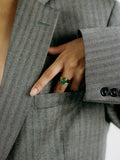 Close up of model's hand wearing Classico Jade Signet Ring (Shiny vermeil tapered signet ring band with Oval Green Jade stone in center). Model's hand is halfway in front pocket of striped business-style jacket. 