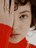 14KT Baby Dome Ring pictured on model's pinky finger. Two other rings featured on middle finger. 