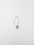 Product image of yellow gold safety pin with skull at base of pin, shot on white background. 