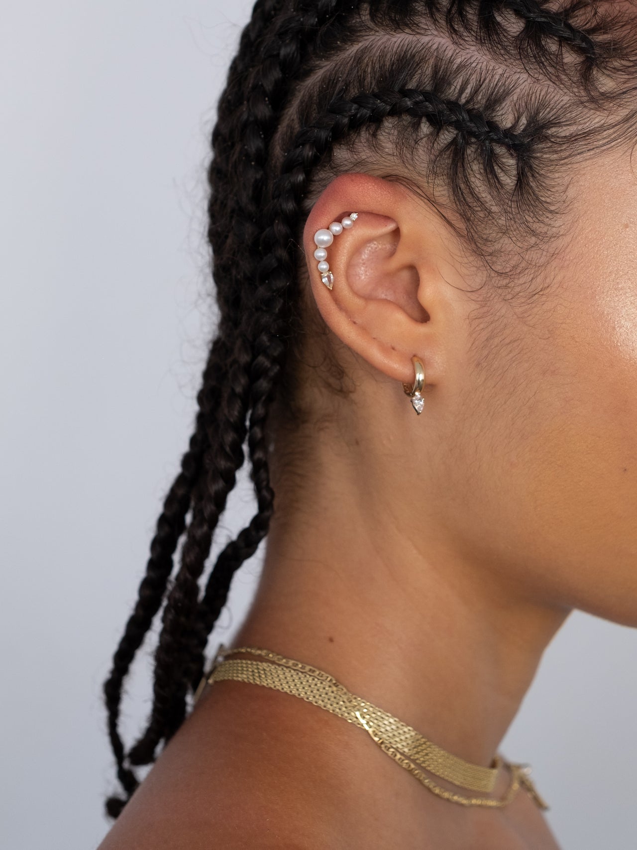 14kt Gold White Sapphire Huggies pictured on models ear. 