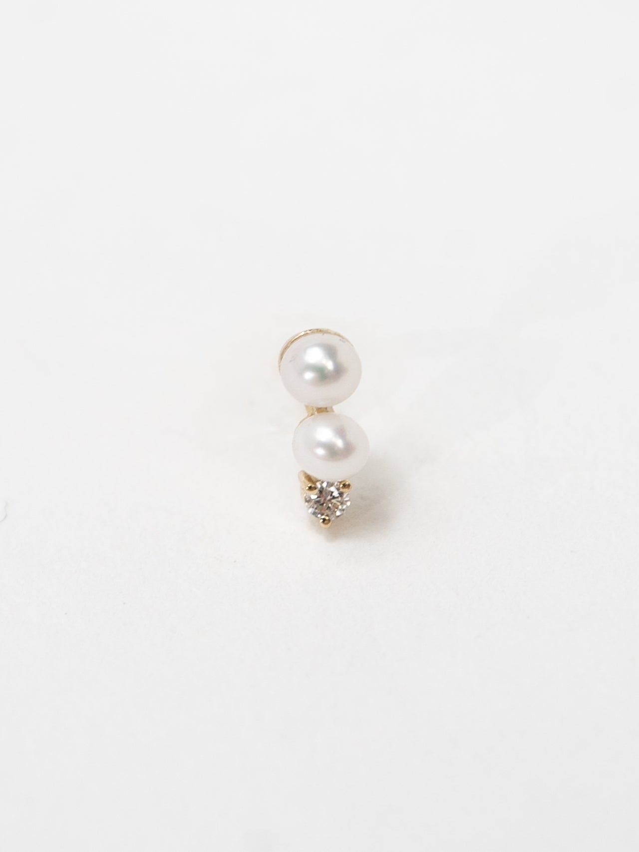 14kt Gold Mini Pearl & Diamond Stud earring pictured on light grey background.
