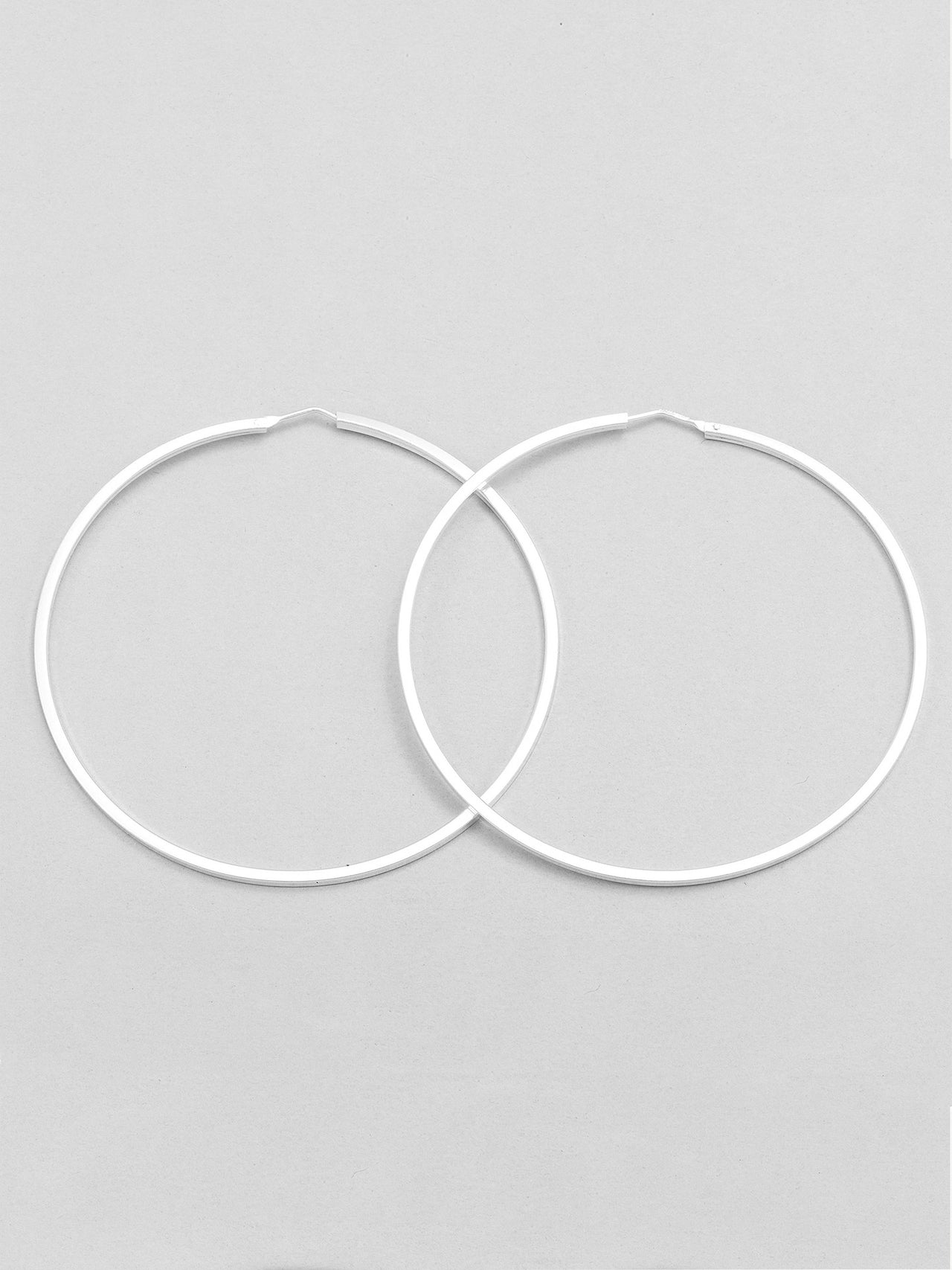 Sterling Silver XL Infinity Hoops pictured on light grey background.
