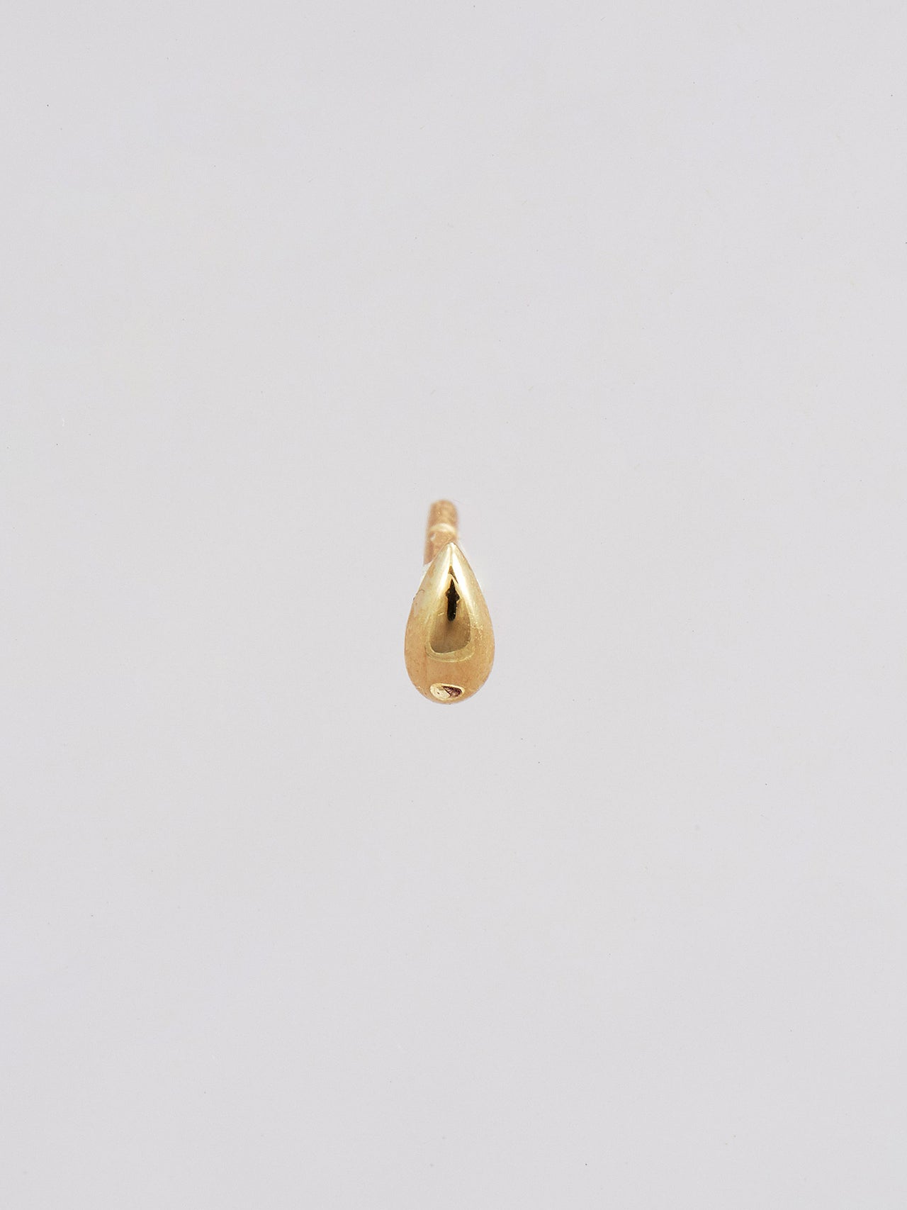 Front product shot of the Mini Teardrop Stud (14Kt Yellow Gold Droplet Stud Earring Diameter: 2X3.5mm) Background: Grey Backdrop