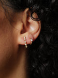 14Kt Yellow Gold Five Diamond Stud Earring pictured on models ear along with our Solo Sparkle Huggie. 