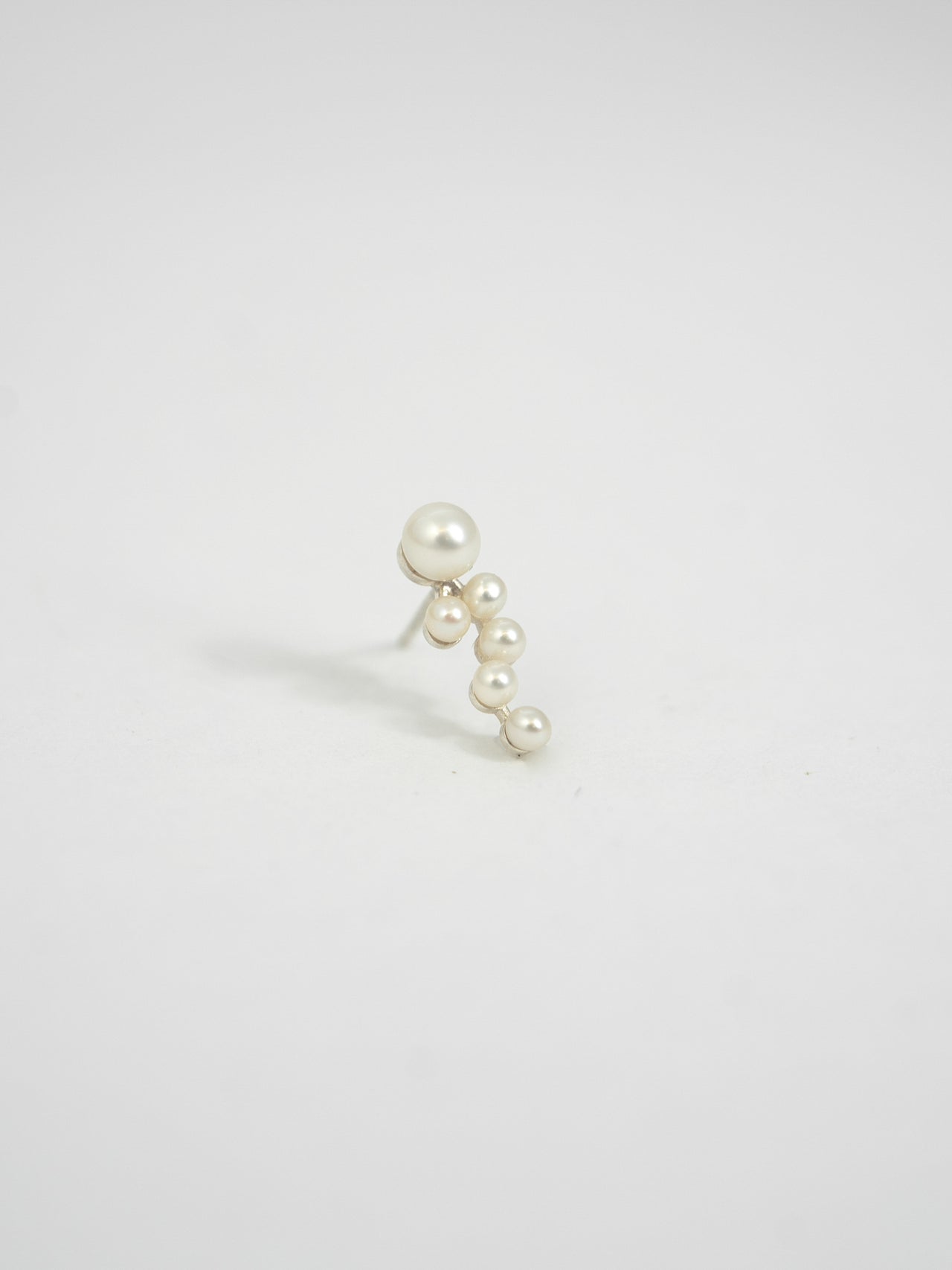 Product image of Astropearl Ear Climber. Larger pearl at base of stud with smaller pearls cascading down. Product shot on white background. 