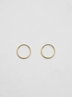 Front product shot of the Mini Infinity Hoops (14Kt shiny Yellow Gold Hoop Earrings  Diameter: 0.75”) Background: Grey backdrop
