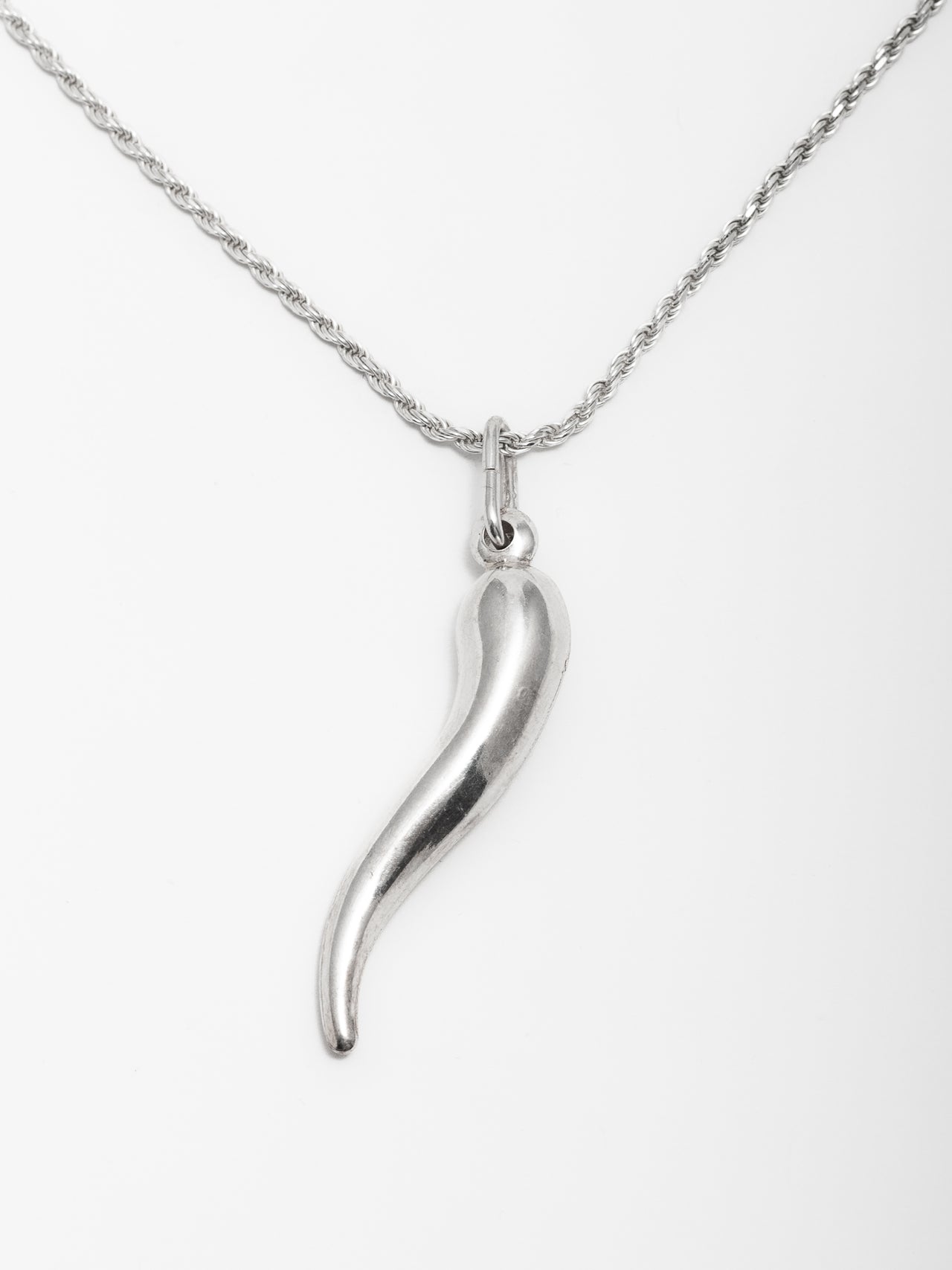 Sterling Silver Italian Horn Necklace pictured on chain. Light grey background. 