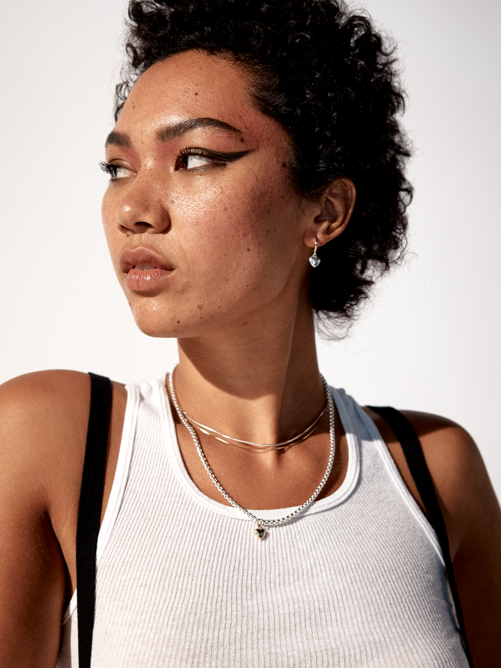 On model image of gordita necklace paired with cocktail chain and gordita huggies.