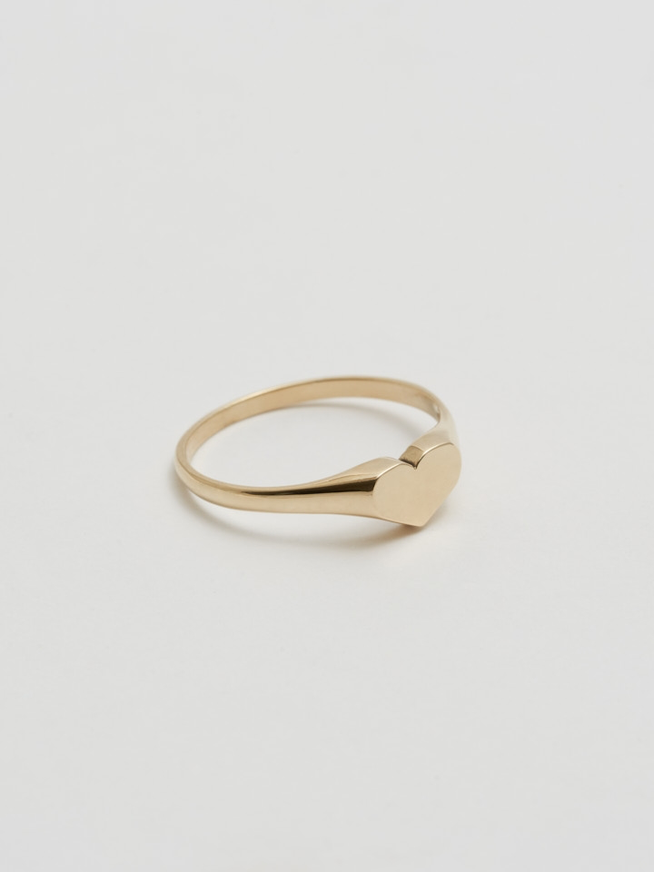 Side Angle shot of Mini Heart Signet (14Kt Shiny Yellow Gold Ring with 5mm Mini Heart Face) with white background