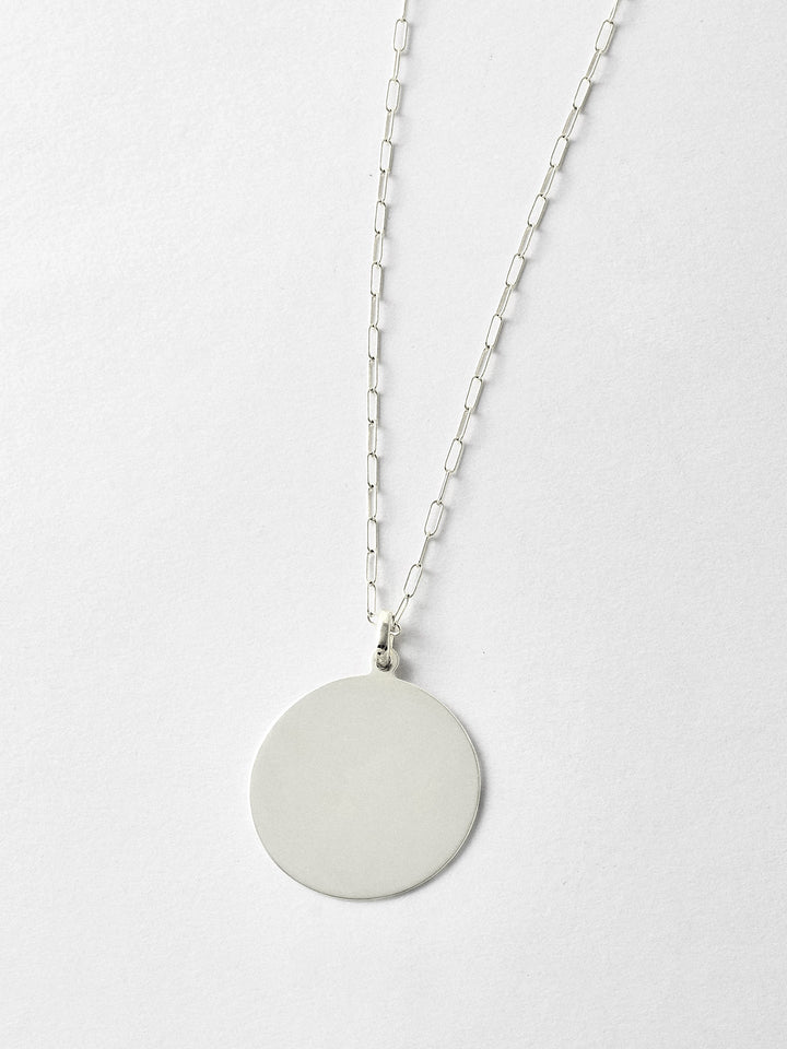 XL Sterling Silver Disk Pendant pictured on light grey background. Worn with the Long Link Chain.