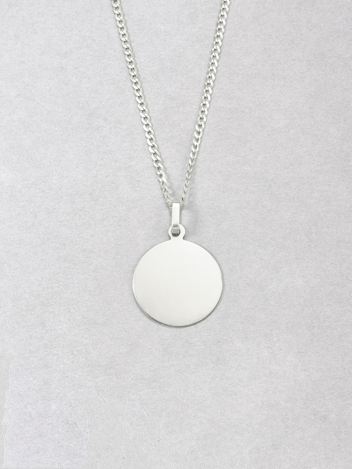 Sterling Silver Disk Pendant pictured on chain. Grey background.