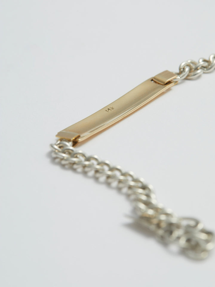 Watts ID Bracelet: Sterling Silver Curb Chain with a 14Kt Gold ID Centerpiece Length: 7’ (adjustable)